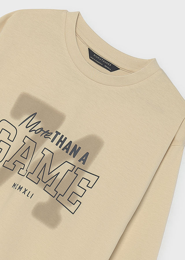 Деталь бежевого лонгсліва для хлопчика: напис More Than a Game та MMXLI