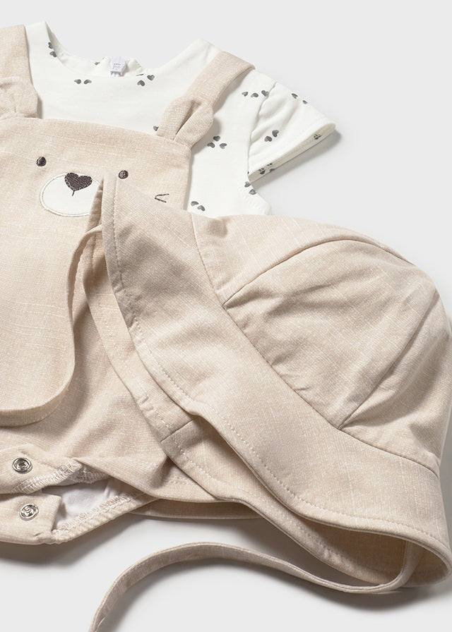 Крупний план бежевого боді-сарафана з мордочкою ведмедика та панами на зав’язках