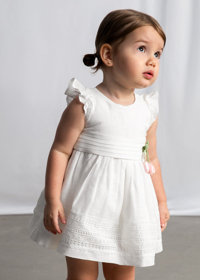 Біла сукня для дівчинки з короткими рукавами-крильцями, декоративним бантом із квітами та мереживною вишивкою по низу