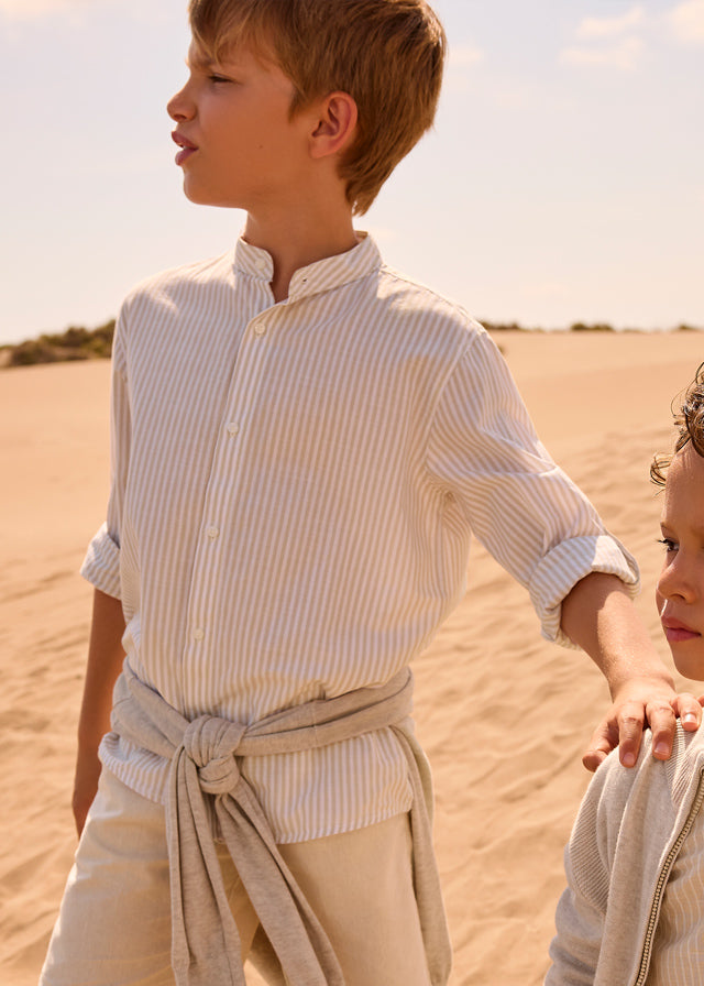 Хлопчик у сорочці для хлопчика в смужку зі стійкою, рукави підгорнуті