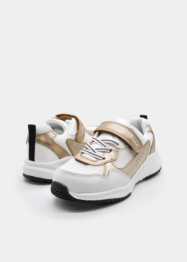Дитячі білі кросівки із золотистими деталями для дівчинки, пара під кутом